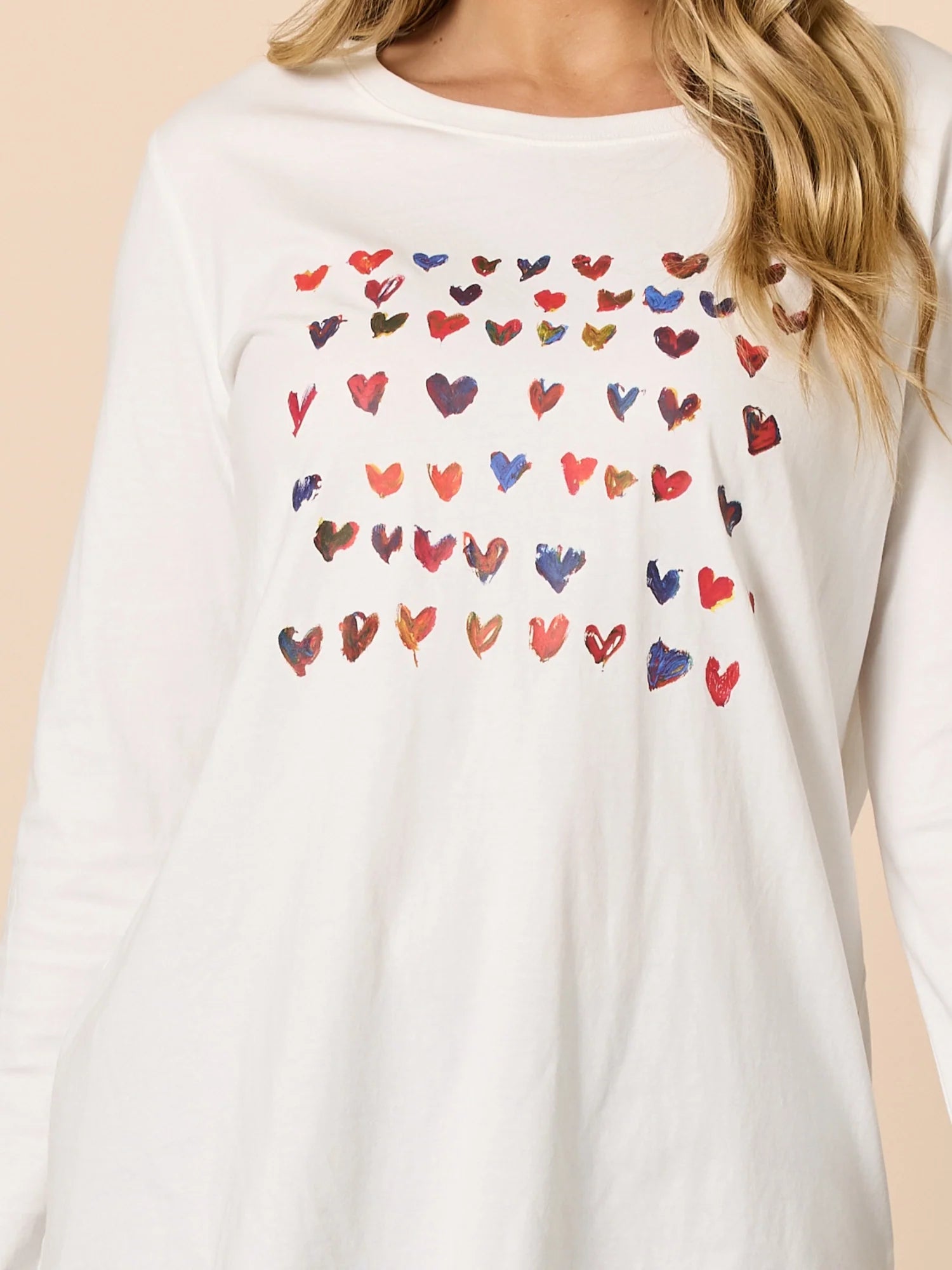 Threadz White long-sleeve shirt with colorful heart patterns on a beige background