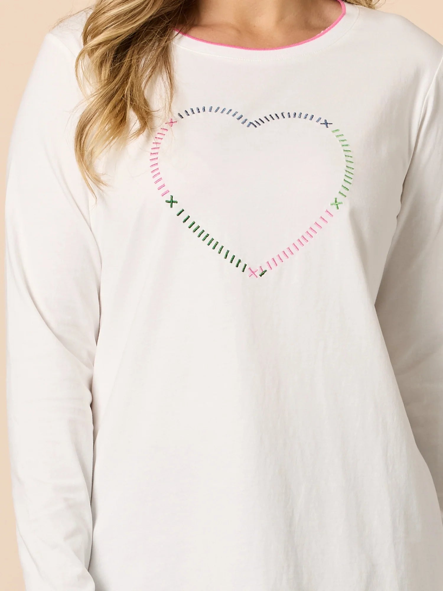 Image of Woman wearing Threadz White long-sleeve shirt with decorative stitching on a beige background
