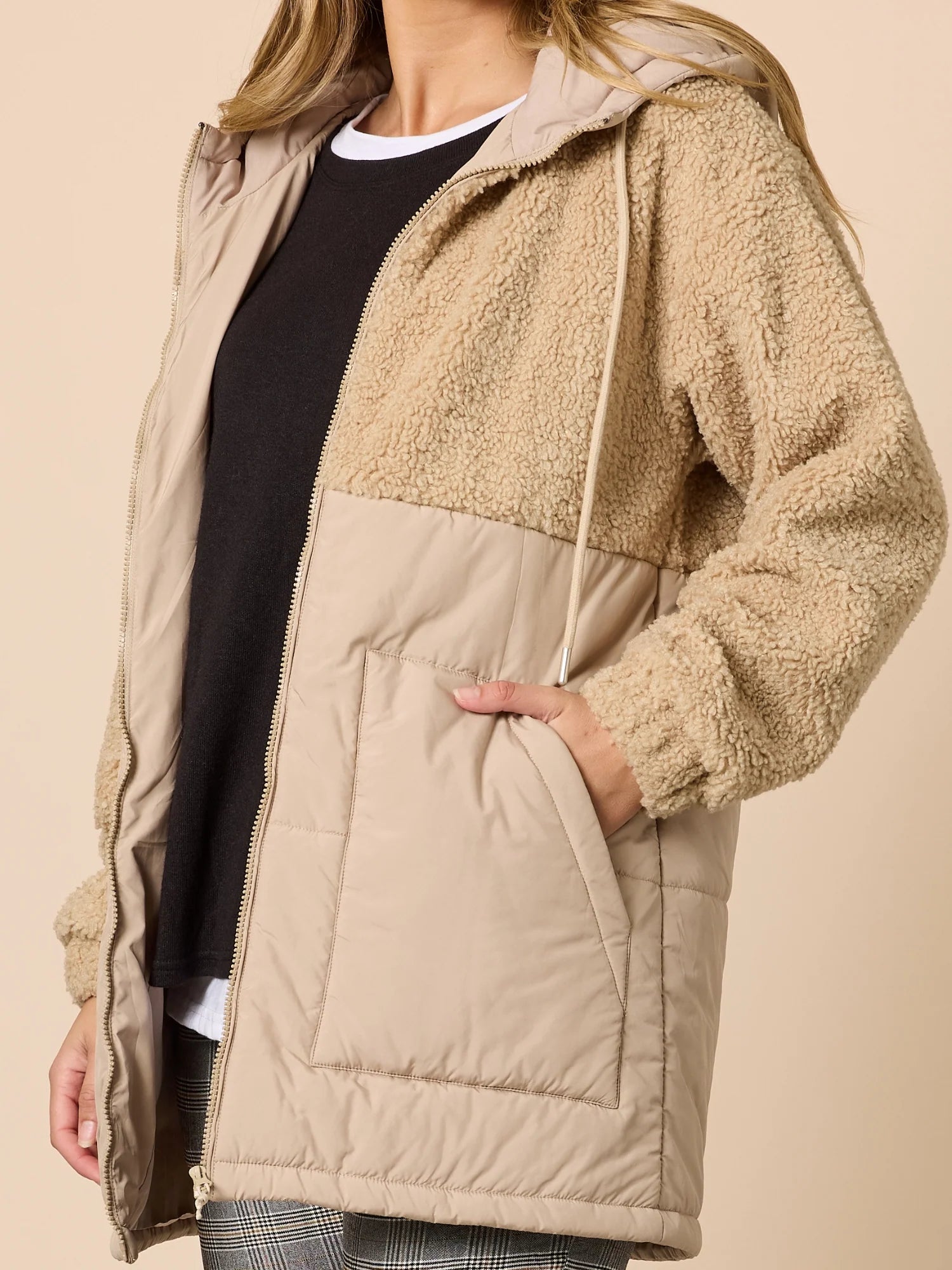 Woman wearing Threadz Beige fleece jacket with a hood on a beige background