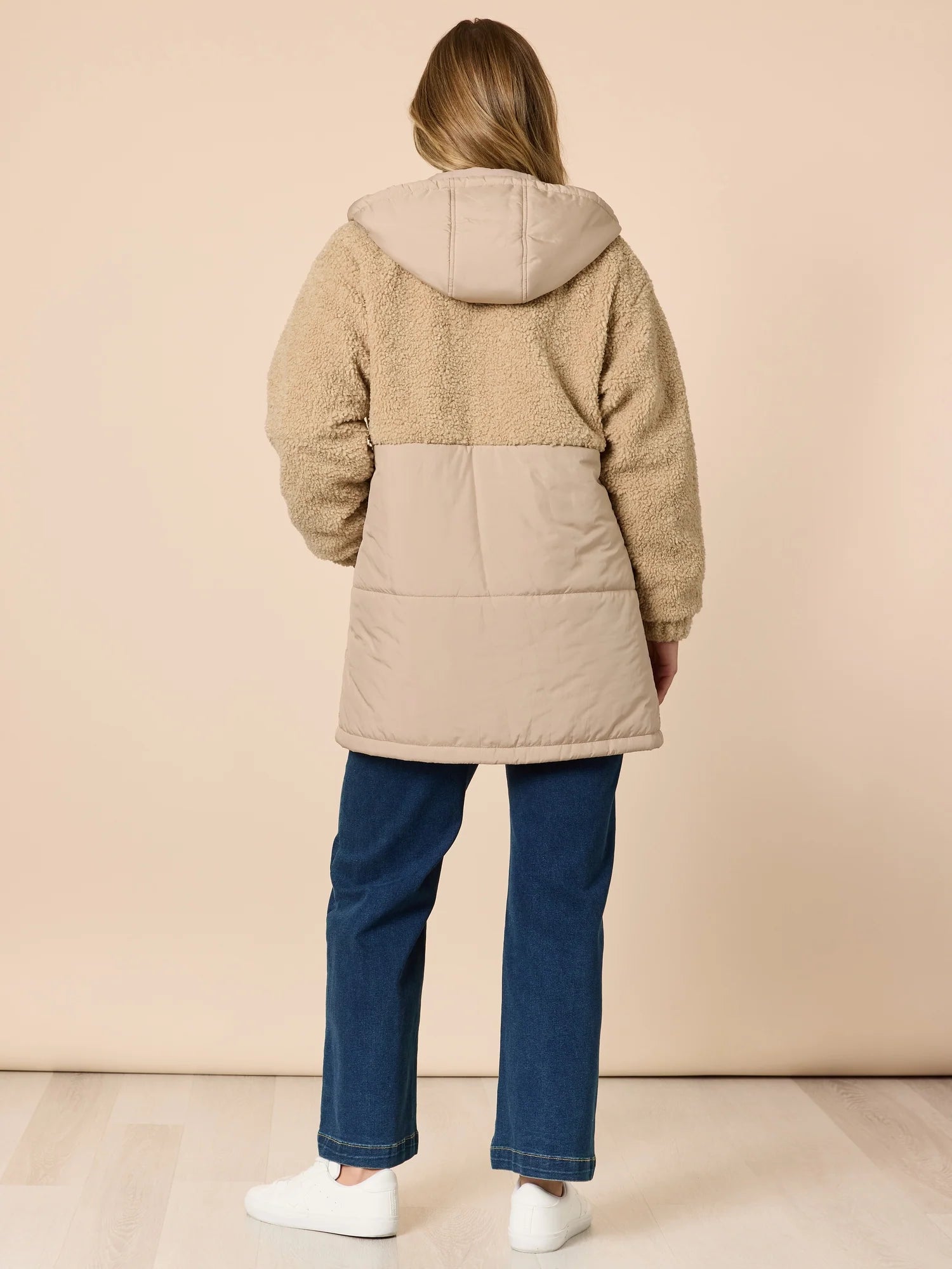 Woman wearing a Threadz beige and brown color-blocked jacket on a beige background