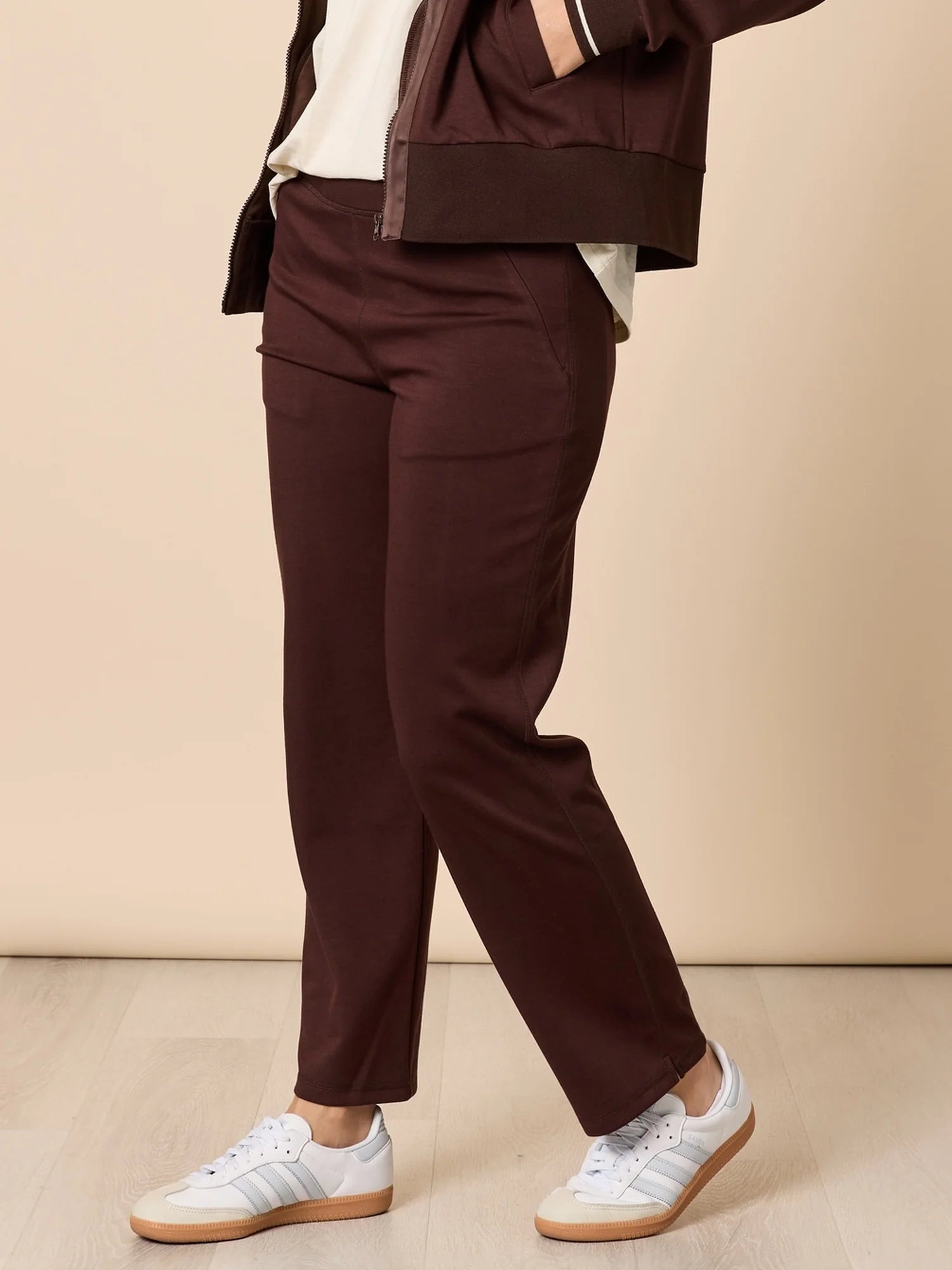 Image of Person wearing Threadz brown pants and a jacket on a beige background