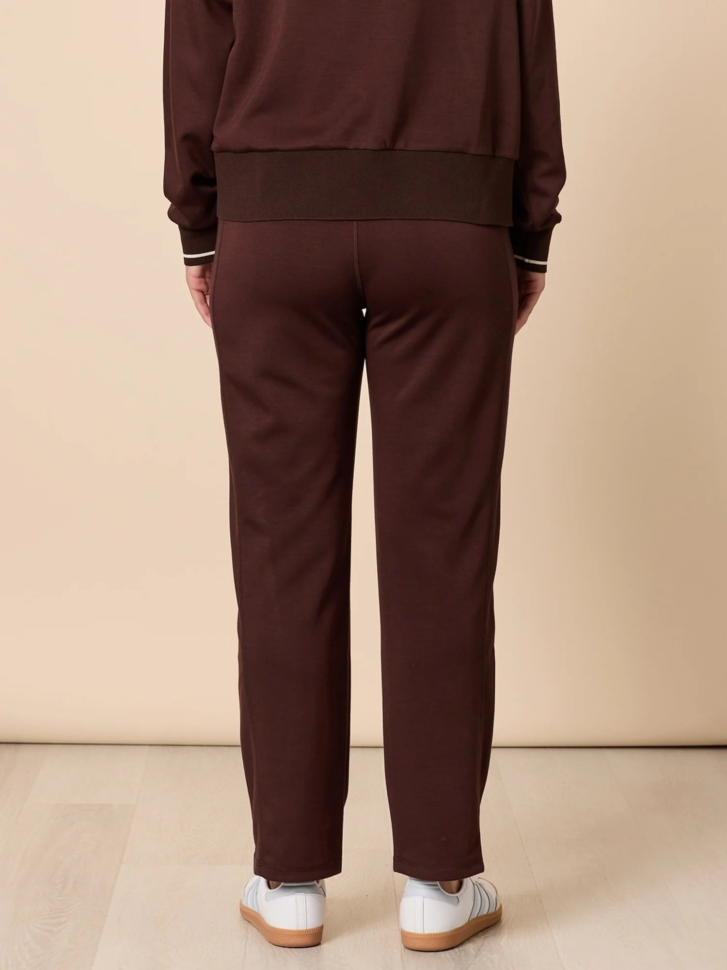 Threadz Brown tracksuit worn by a woman on a beige background