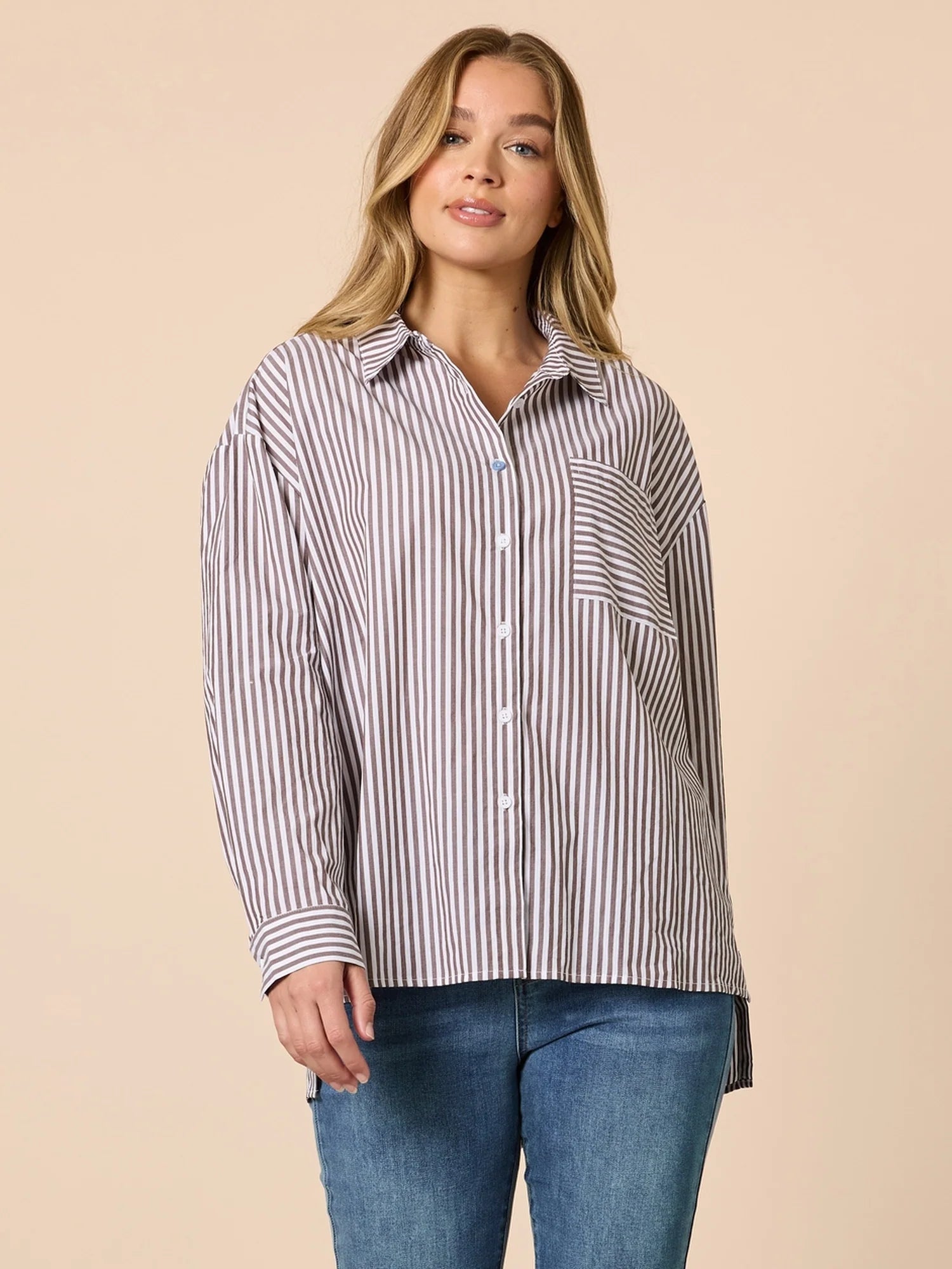Woman wearing a Threadz striped shirt and jeans on a beige background