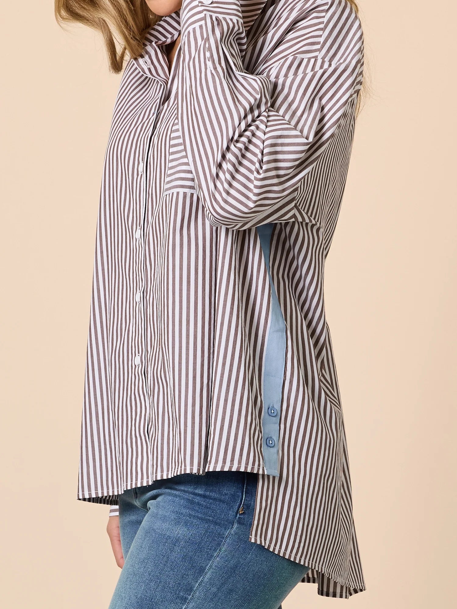 Image of Woman wearing a Threadz striped shirt with a beige background