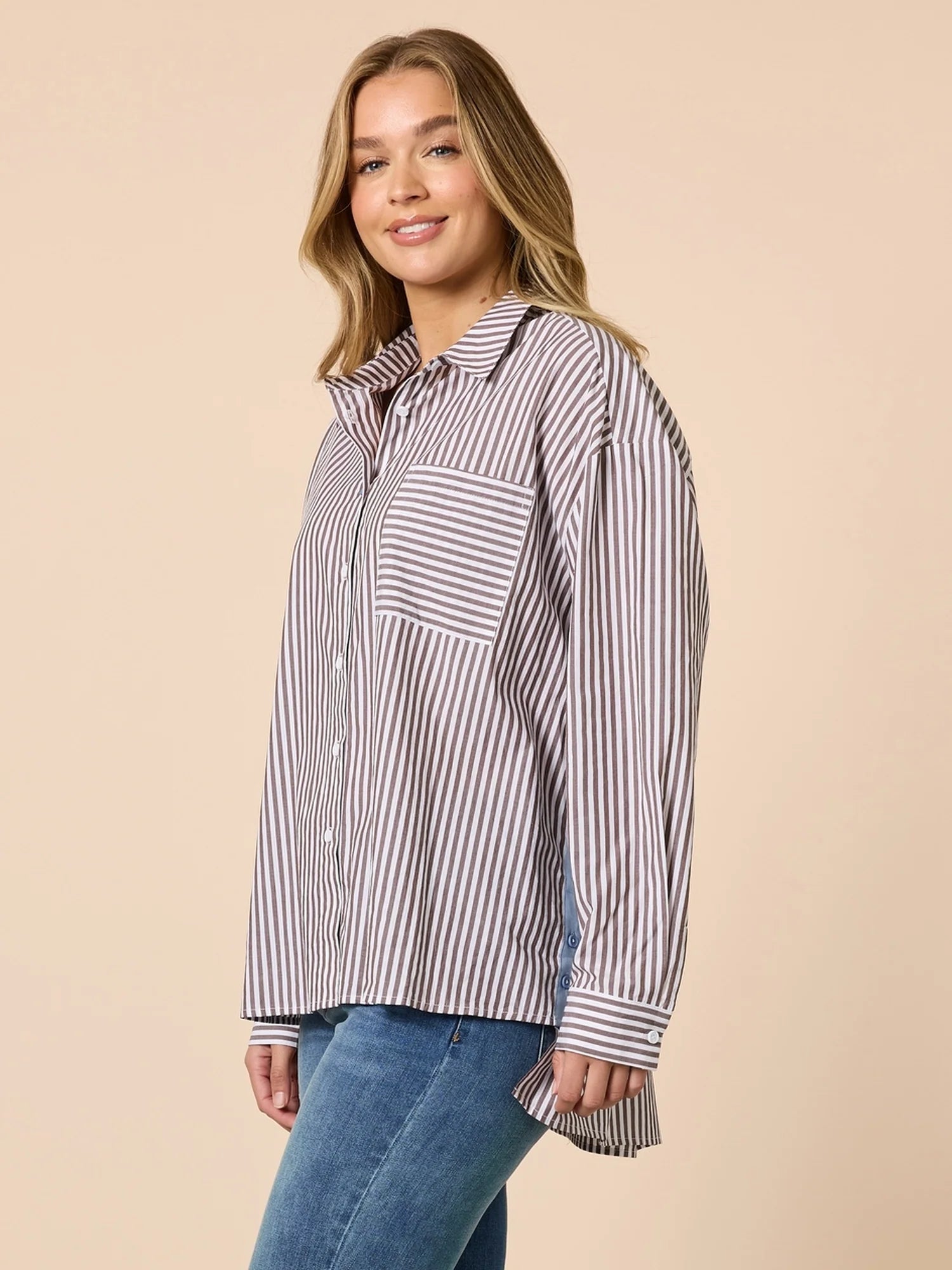 Image of Woman wearing a Threadz striped shirt and jeans on a beige background