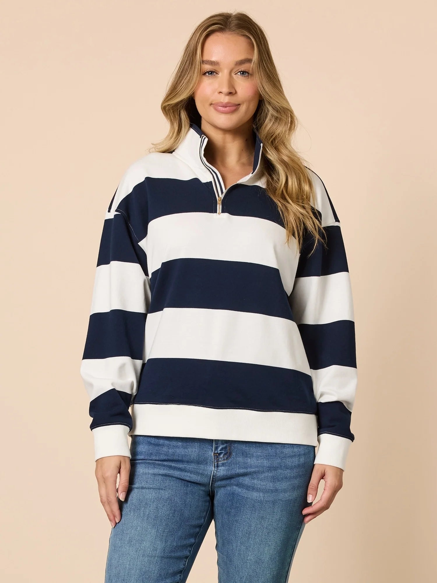 Collection of Woman wearing a navy and white striped sweater with blue jeans on a beige background in a gallery layout
