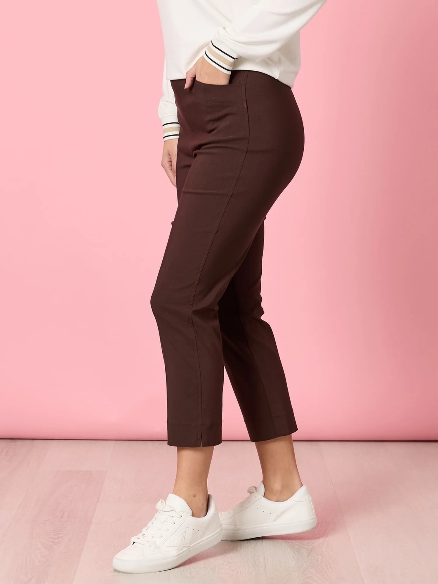 Collection of Woman wearing Threadz brown pants and white sneakers against a pink background in a gallery layout
