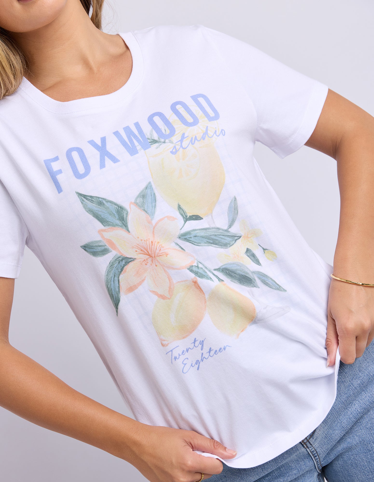 Image of White t-shirt with floral design and 'FOXWOOD' branding on a plain background