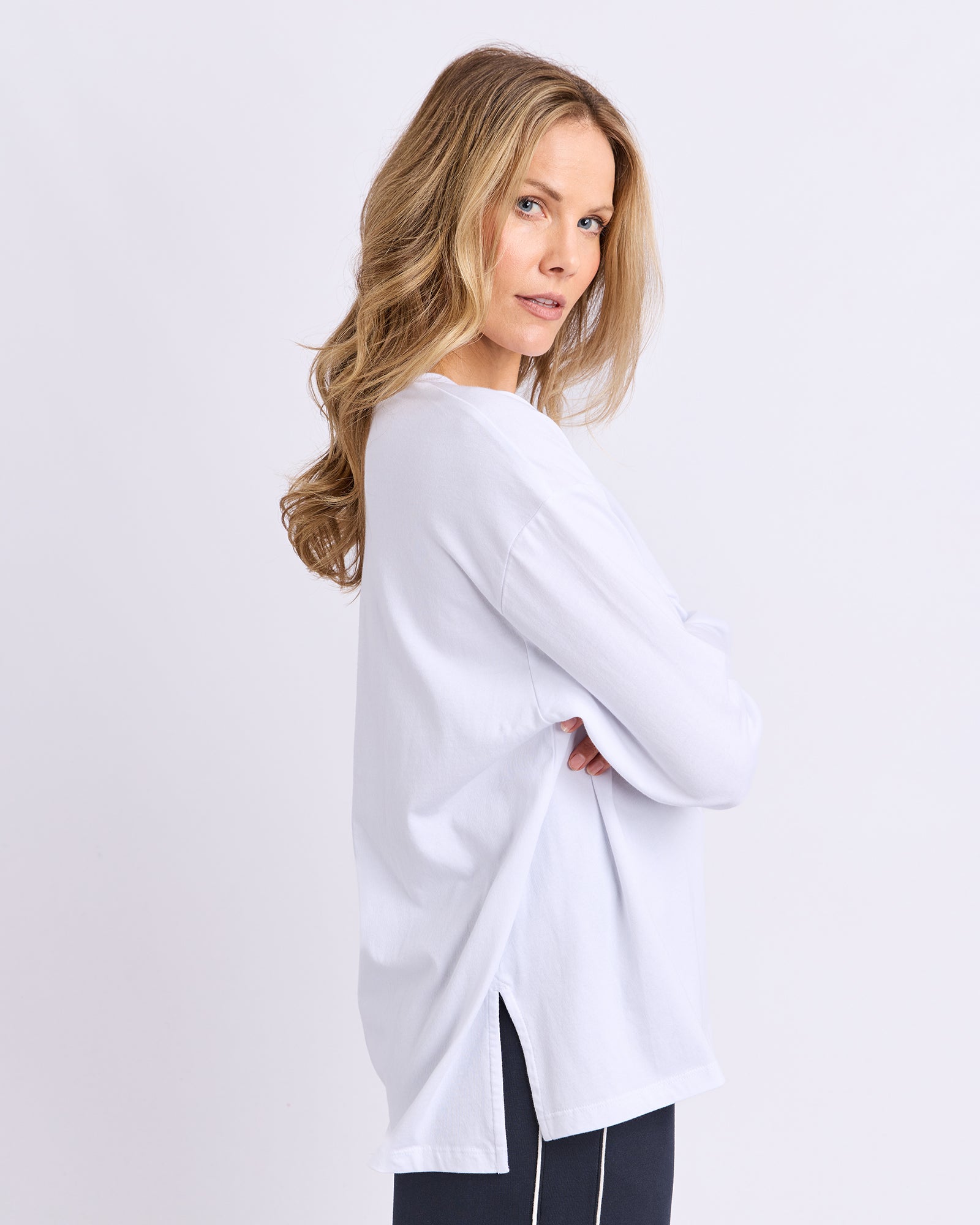 Image of Woman wearing a white long sleeve Foxwood Tee against a plain background
